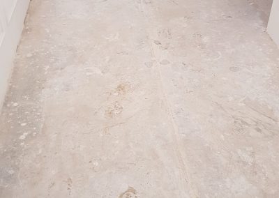 Authentieke Bianco Carrara vloer onder lijmlaag. Vloer schuren, polijsten en repareren.